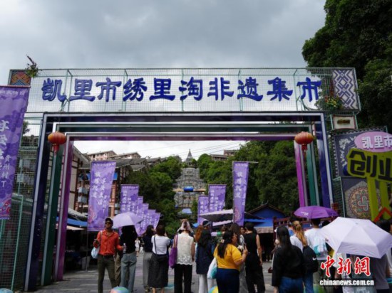 7月4日，贵州省凯里市苗侗风情园内，游客“打卡”绣里淘非遗集市。该集市目前已聚集700余户商家，涵盖刺绣、银饰、蜡染等6000余种非遗文创产品，这些产品既传承了传统手工技艺，又融入现代设计元素，兼具民族韵味与时尚美感，因而吸引了不少海内外游客专程前来“淘宝”。中新社记者 周燕玲 摄